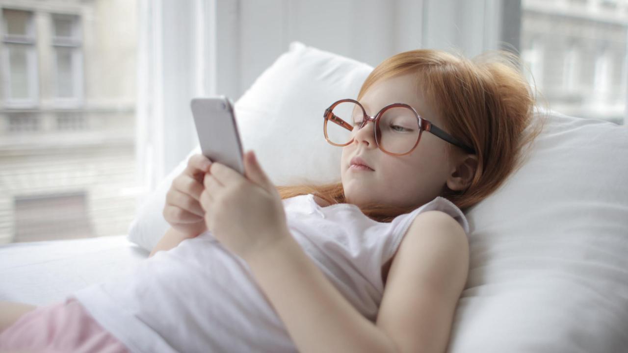 A young girl uses a smart phone.
