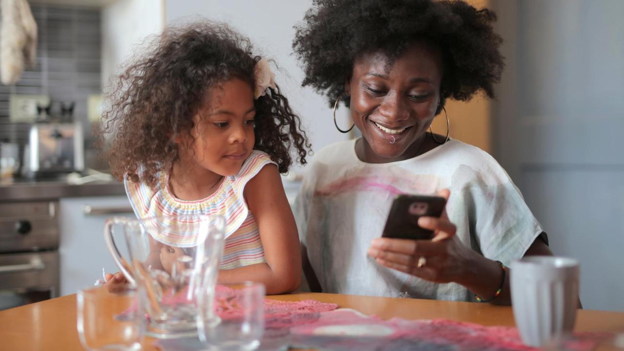 Mom using phone by daughter